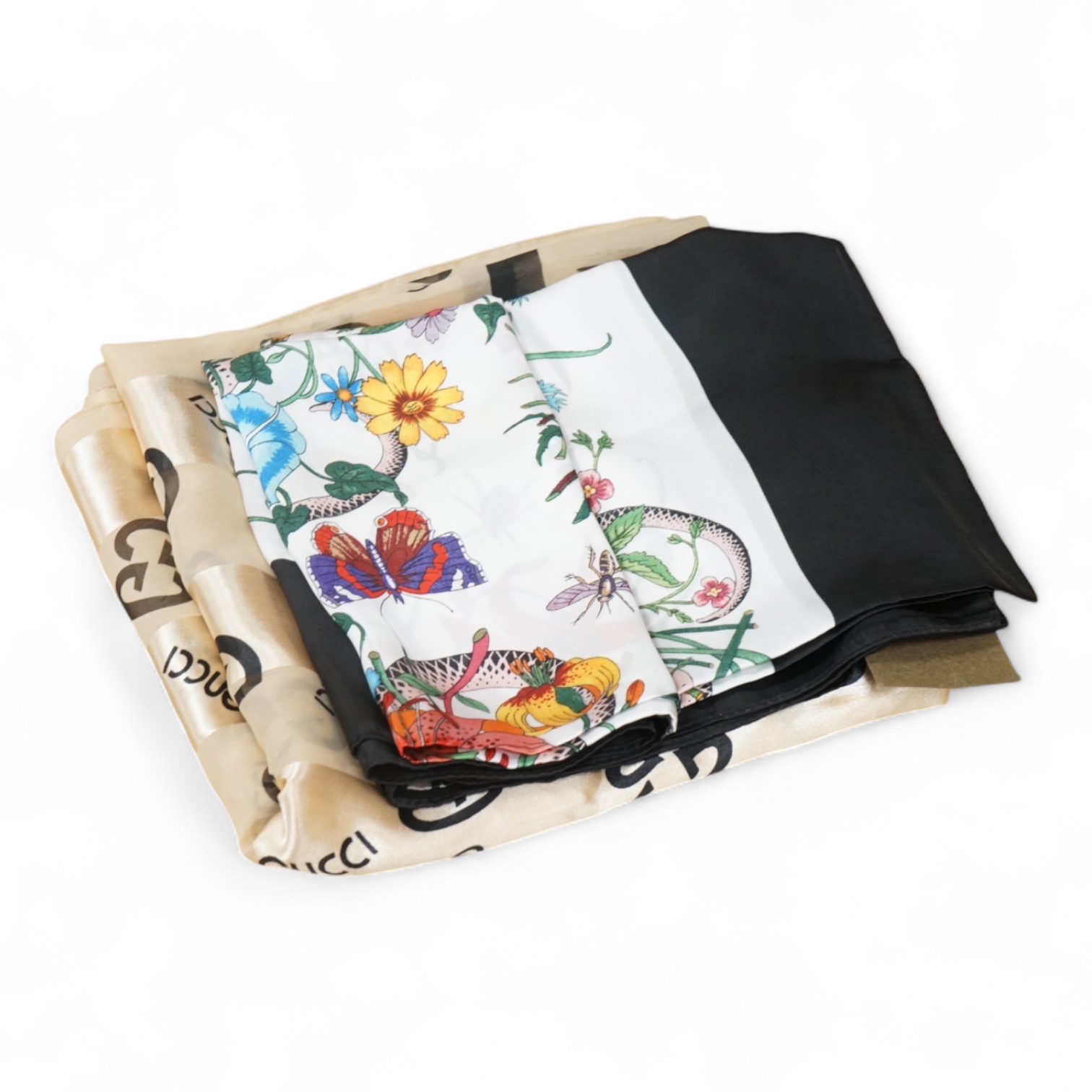 A Gucci floral silk scarf, with label and tag, a Gucci silk and net monogrammed scarf and a green & red monogrammed silk hair or bag ribbon